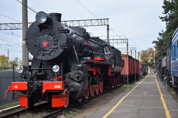 Fototapeta na wymiar Old black and red steam train on rails