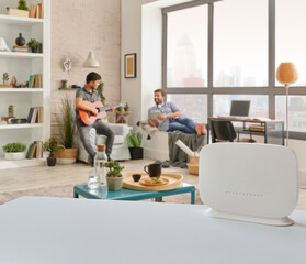 Router interior room on the table and two man is accessing internet.