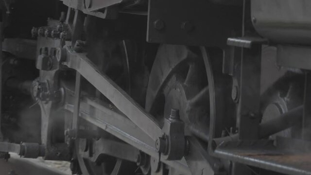 Old Vintage Locomotive Transportation Revolution. History. smoke of old historic locomotive
Steam engine train wheels passing in slow motion. Historical technology.