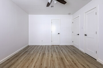 Empty bedroom with open doors leading to the livingroom, bathroom and a closet