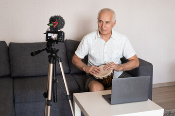 Senior drum teacher recording a tutorial on video at home