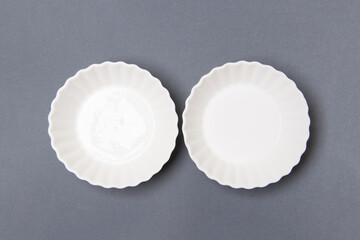 two empty white plate on gray colored paper background