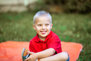 Portrait of a cute little boy with Down syndrome, disabled child laughs and rejoices, caring for...