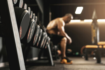 Dumbbells with free space and blurred bodybuilder on background