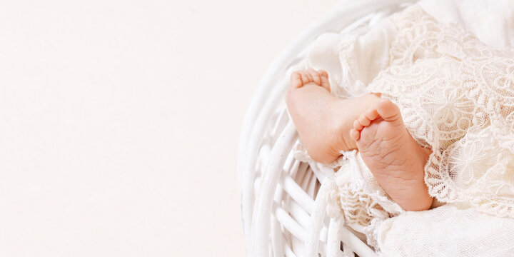 Newborn baby feet on openwork plaid. Closeup picture. Tiny newborn baby's feet  closeup. Copy space. Banner