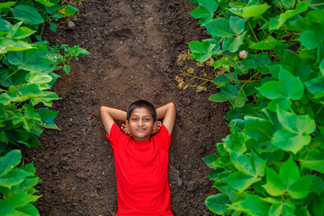 Smiling cute indian boy laying on ground