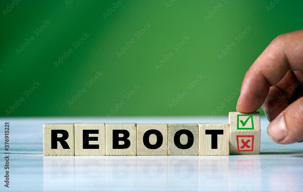 Poster the hand turns the wooden cube and changes the word reebot with green positive tick check box and re