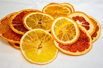 Organic homemade dried orange and grapefruit chips slices on light background