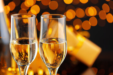 Champagne glass on blurred garland lights background
