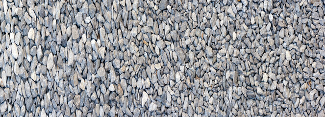 small road stone panorama background. dark gravel pebbles stone texture