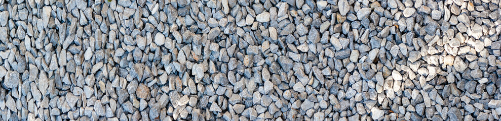 small road stone panorama background. dark gravel pebbles stone texture
