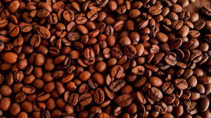 Obraz premium Shaded background of coffee beans scattered on the table.