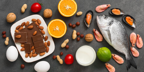 Food allergens. Seafood, milk, chocolate, nuts, citrus fruits, eggs. Allergic food concept. Top view, flat lay, banner.