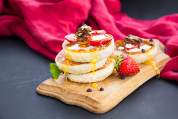 A healthy breakfast of pancakes, strawberries, chocolate, and honey