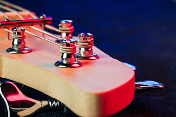 Guitar headstock with tuners on dark background