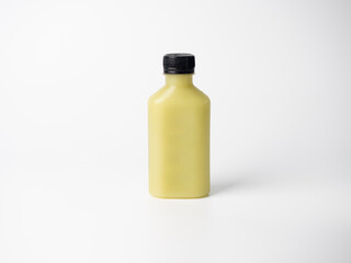 yellow pastel color drink in plastic bottle container with empty logo label. mixed many vegetables and fruits smoothie juice on studio background.
