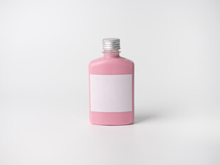 pink pastel color drink in plastic bottle container with empty logo label. mixed many vegetables and fruits smoothie juice on studio background.