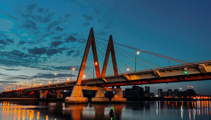 Fototapeta na wymiar Millenium bridge in Kazan, reflected in the waters of the river Kazanka. Cable-stayed bridge across the river. The bridge with night lighting.