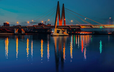 Millenium bridge in Kazan, reflected in the waters of the river Kazanka. Cable-stayed bridge across the river. The bridge with night lighting.