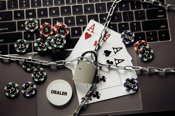 Stop online casino concept with padlock, playing cards and keyboard. Top view.