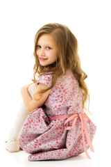 Beautiful blonde in a dress sitting on the floor hugging her knees.