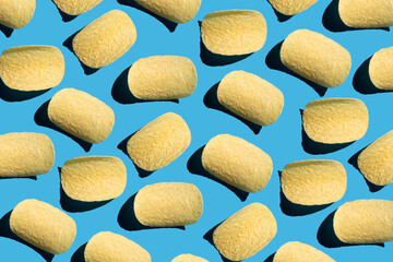 Yellow potato chips on blue background. Snacks pattern. Top view. Repetition concept.