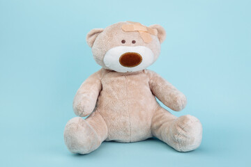 Stuffed Bear animal as a symbol of children healtcare concept isolated on blue background.