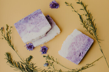 Cosmetic soap with flowers on yellow background.