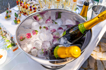 Luxury holiday composition. A bottle of chilled champagne in an ice bucket and vintage glasses. Festive table in the background.