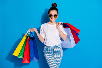 Portrait of positive cheerful girl have free time walk shopping center buy purchase hold bags wear...