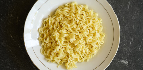stock photo tasty yellow noodle on a white plate and a stone pad