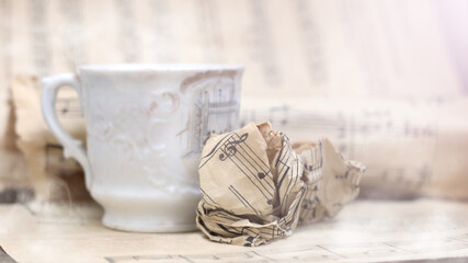 A white cup of coffee with steam and a musical note
