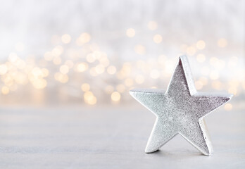 Christmas star, decor on bokeh silver background. Christmas or New Year minimal concept.