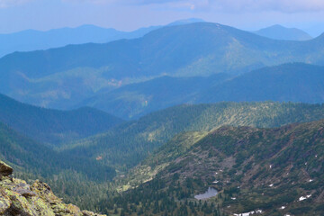 view of mountain small lake among snowy glaciers, green emerald blue mountain ridges overgrown with trees, Chersky peak