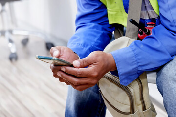 A silhouette of a young man working from home using a smartphone