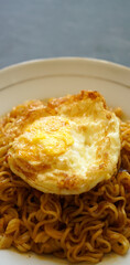 stock photo tasty fried noodle with fried egg on a white plate and a stone pad