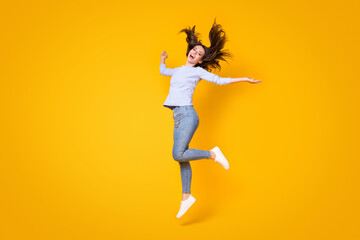 Fototapeta na wymiar Full length body size view of her she attractive pretty thin cheerful cheery girl jumping throwing hair having fun good mood walking isolated bright vivid shine vibrant yellow color background