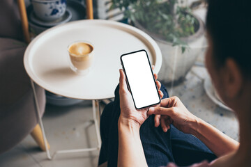 cell phone mockup blank white screen.woman hand holding texting using mobile on desk at coffee...