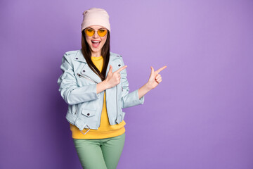 Portrait of crazy cheerful girl promoter point index finger copyspace incredible sales ads promotion display recommend choose decide wear good look clothes isolated violet color background