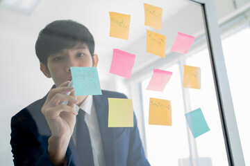 Businessman Writing on Adhesive Notes.