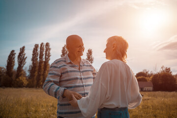 happy senior couple dating, hugging and kissing outdoor at sunset