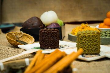 Mid-Autumn Festival moon cake, colorful food and drink on burlap background