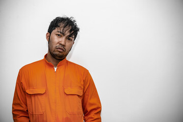 Fototapeta premium Prisoner in orange robe concept,Portrait of asian handsome man in Prison uniforms,Bandit has a lot of muscle,