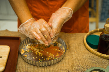 Female hands making dough for mooncake, homemade cantonese moon cake pastry on baking tray before...