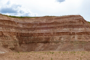 Working wall in industial quarry (open-pit mining). It can be seen layers of underground resources