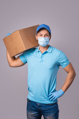 Fototapeta na wymiar Young delivery man is wearing prevention mask and gloves with a cardboard boxes