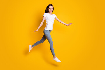 Fototapeta na wymiar Full length body size view of her she nice attractive pretty cheerful cheery thin girl jumping walking strolling enjoying leisure isolated bright vivid shine vibrant yellow color background
