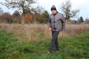 old positive man in a hat with a smile walks in nature, concept of a healthy lifestyle, close-up