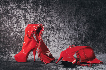 Kinky red high lacquer boots on a dark chic background
