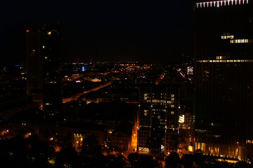 Fototapeta na wymiar beautiful view from a height, from the window to the night modern European city of Frankfurt am Main with lights, tall skyscrapers, the concept of global business, traffic